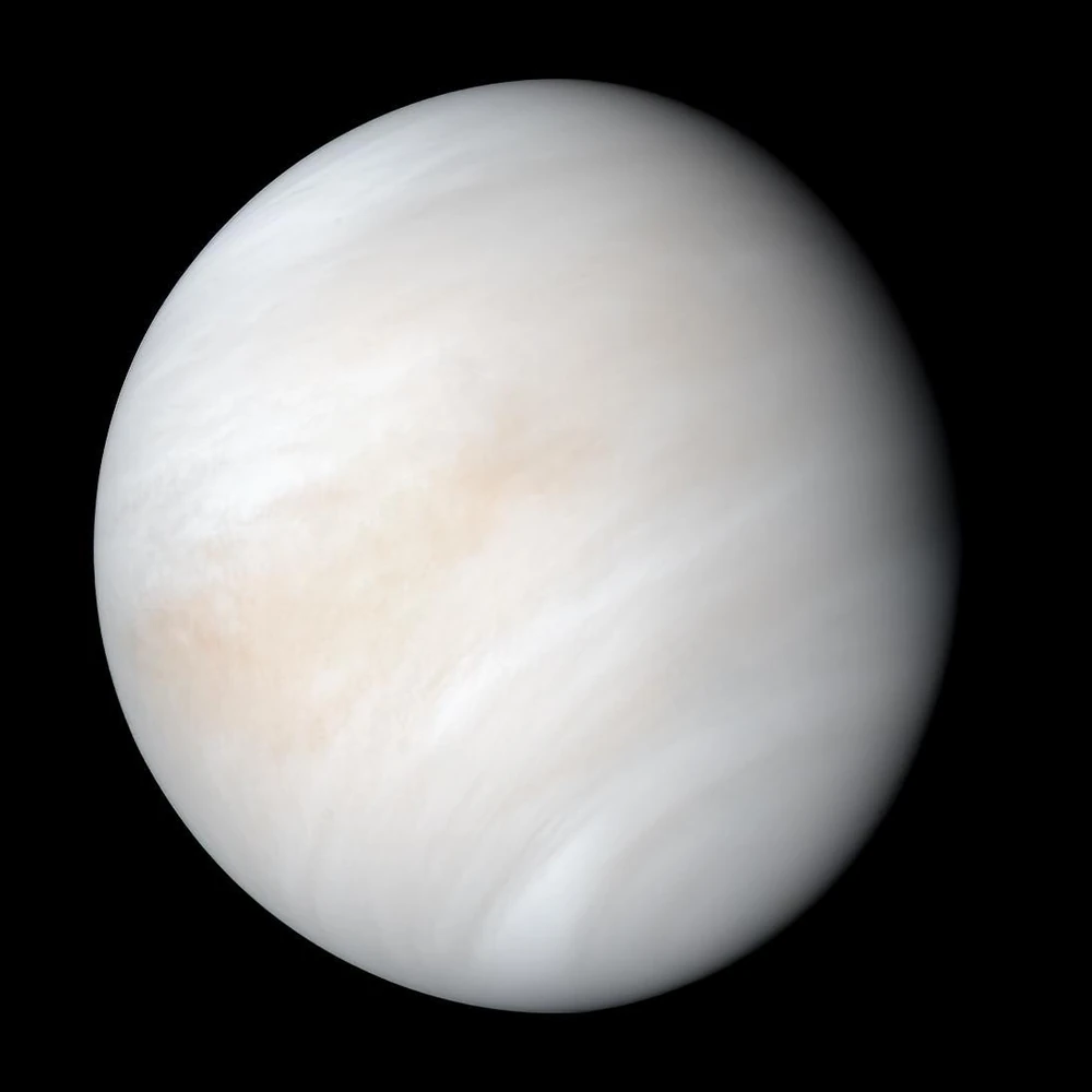 Photo of the planet Venus as a pale cream globe of clouds, taken by NASA's Mariner 10 spacecraft in 1974